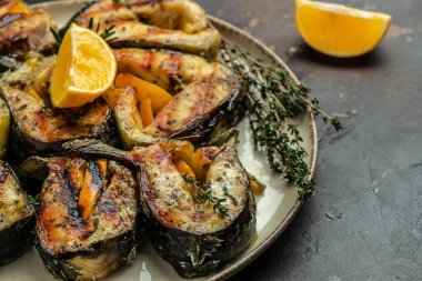 Grilled fish steak sturgeon with lemon herbs and spices, on a dark background, Restaurant menu, dieting, cookbook recipe top view,