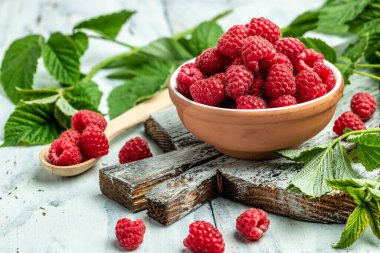 Beyaz ahşap arka planda kırmızı ahududular kasede. Organik ahududu. Kırmızı dut. Uzun afiş biçimi. metin için yer.