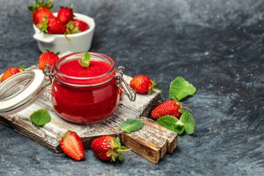 Çilekli kavanoz çilek reçeli. Ev yapımı çilekli marmelat ve tahta tahtada meyveler. Uzun pankart biçimi.