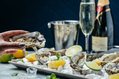 Yarım kabuklu istiridye. Kokteyl soslu taze istiridye ve taze limon. Restoranda istiridye yemeği..