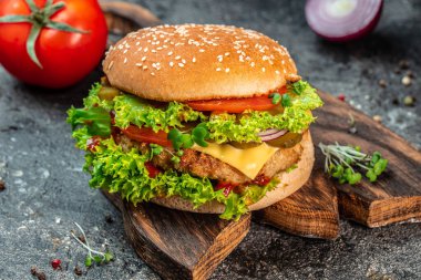 Sığır eti, domates, peynir, pastırma ve marullu ev yapımı leziz ızgara burger. Fast food ve abur cubur kavramı.