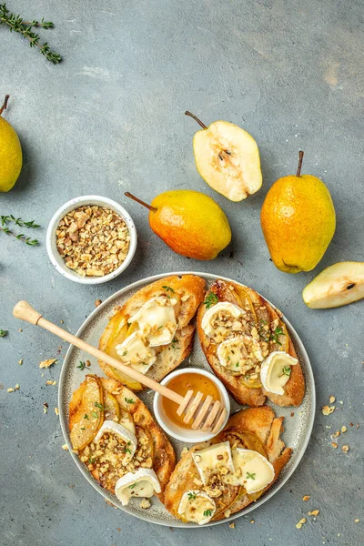 Appetizer bruschetta with pear, honey, walnut and thyme, New Years Eve or Christmas party, vertical image. top view. place for text,