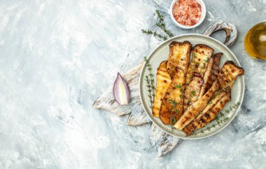 grill eryngii slice Oyster mushroom King mushrooms Eringi on a wooden board on a light background. banner, menu, recipe place for text, top view.