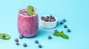 Bilberry yogurt cocktail on a blue background. Natural detox. top view. place for text.