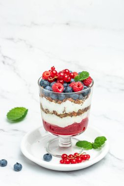 Yoğurtlu granola parfe yaban mersini ve ahududu. dikey görüntü. Üst Manzara. metin için yer.