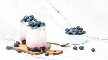 parfait blueberries with yogurt and blueberry jam. Healthy breakfast. Super food healthy eating vegetarian vegan food on a light background. Long banner format place for text.