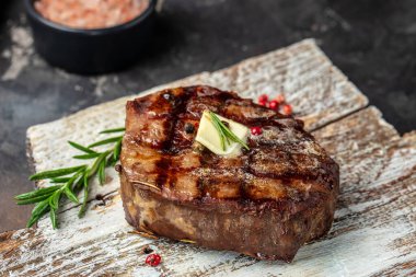 filet Mignon with a piece of butter on a wooden board. Restaurant menu, dieting, cookbook recipe top view,