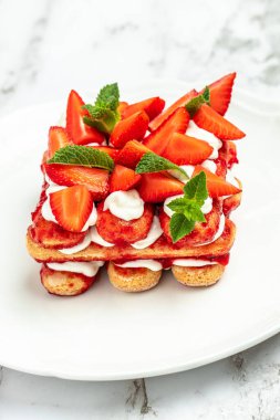 Tiramisu. Homemade tiramisu cake with fresh strawberry, mascarpone and mint. Tiramisu portion on plate. vertical image. top view. place for text.