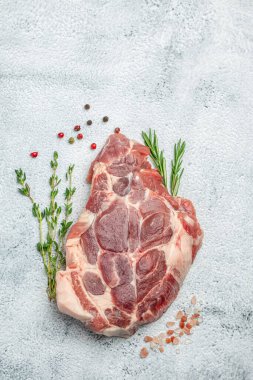 Raw meat pork steaks with seasoning on a light background. vertical image. top view. place for text.