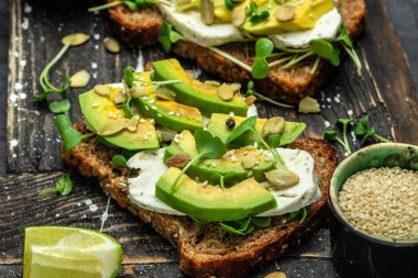 Peynirli, kabaklı, fındıklı ve susamlı avokado tostu. Sağlıklı yağlar, kilo vermek için temiz yiyecekler..