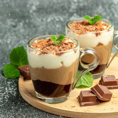 Tahta bir tahtanın üzerinde cam bir kavanozda üç çikolata. Yemek tarifi geçmişi. Kapat..