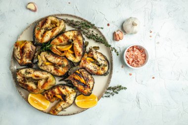 Hafif arka planda ızgara mersin balığı, restoran menüsü, diyet, yemek tarifi üst görünümü.