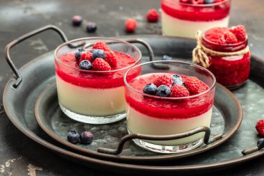 Krem şanti ve naneli ahududu şerbeti. Küçük kavanozlarda siyah arka planda İtalyan tatlısı. metin için yer.