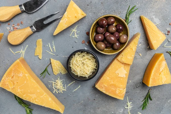 Parmesan cheese, Hard cheese, olives rosemary. place for text, top view.