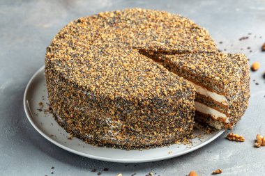 Katmanlı kek, üzerinde konsantre süt ve yemek tarifi olan fındıklı kek. Kapatın. Katmanlı haşhaşlı kek.,