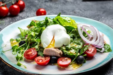 Haşlanmış ton balığı salatası, yumurta, marul, kiraz, domates zeytin ve mısır, koyu taş ya da beton arka planda. Üst Manzara. Boşluğu kopyala.