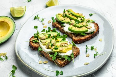 Peynirli, kabaklı, fındıklı ve susamlı avokado tostu. Sağlıklı yağlar, kilo vermek için temiz yiyecekler..