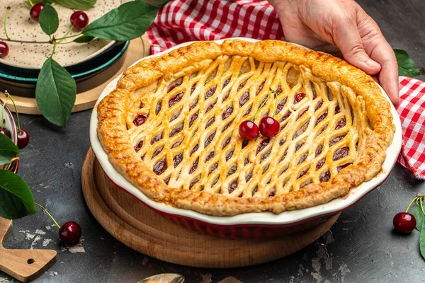American homemade cherry pie, Female hands holding whole homemade cherry pie, banner, menu, recipe place for text, top view,