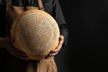 cheesemaker mele hands holding wheel hard cheese,