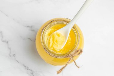 Ghee ya da tereyağı. Pişirme yağı, saf kahve. Sağlıklı yağ diyeti konsepti. afiş, menü, metin için tarif yeri, üst görünüm.