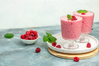 Ahududulu smoothie milkshake ya da böğürtlenli cam kavanozda yoğurt. Mavi arka planda yoğurt kokteyli. metin için yer, üst görünüm,