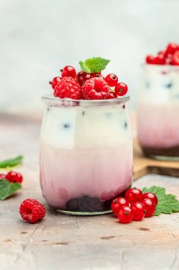 berries Yogurt. Healthy layered dessert with yogurt, jam, red currant and raspberries. Natural detox. vertical image