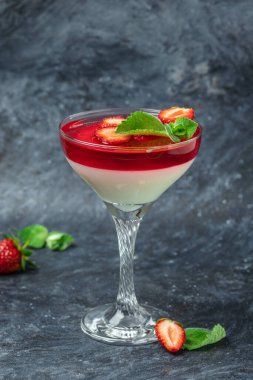 Çilek soslu jöle ve naneli panna cotta vanilya. İtalyan tatlısı, dikey görüntü. Üst Manzara. metin için yer.