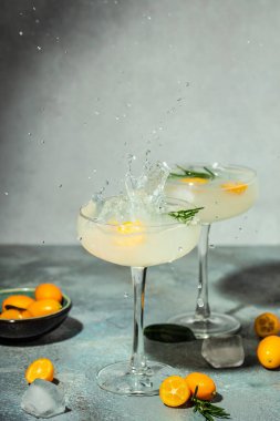 Iced kumquat cocktail with ice. Freeze motion splash drops of refreshing soda. vertical image. top view. place for text.