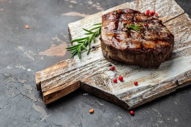 Fresh juicy delicious beef steak on a wooden board. Restaurant menu, dieting, cookbook recipe top view.