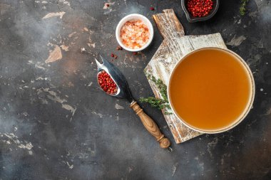 Bone meat chicken broth in a bowl on a dark background, banner, menu, recipe place for text, top view.