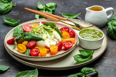 Burrata peyniri. Koyu arkaplanda taze sebze salatası. Sağlıklı beslenme konsepti. Restoran menüsü, diyet, yemek kitabı tarifi üst görünümü.