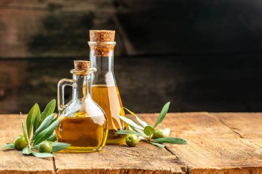 Zeytinyağlı yeşil zeytin. Ahşap arka planda ekstra saf zeytinyağı kavanozları. metin için yer.