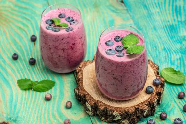 Bilberry yogurt cocktail on a blue background. Natural detox. top view. place for text.