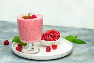 raspberries smoothie milkshake or yogurt in glass jar with berries. Yogurt cocktail on a white background. place for text, top view.