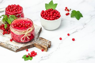 Preserved berry Homemade jam. Glass jar with red currant jam on a light background. Long banner format. top view.