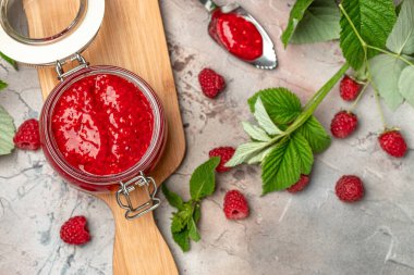 Ahşap tahtada ahududulu ev yapımı reçel. afiş, menü, metin için tarif yeri, üst görünüm.