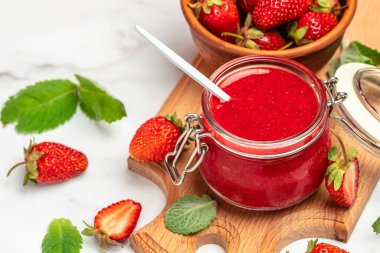 Kavanozda çilek reçeli ve tahtada taze böğürtlen. afiş, menü, metin için tarif yeri.