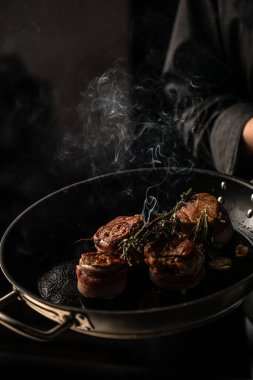 beef tenderloin steak is grilled in a grill pan with steaming. vertical image. top view. place for text.