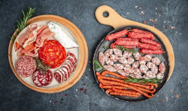 Et tabağı mezeleri. Kuru sosisler koyu bir arka planda. Uzun afiş biçimi. en üstteki görünüm.