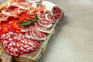 Spanish tapas sliced sausages salami, fuet and chorizo on a wooden board. place for text, top view.
