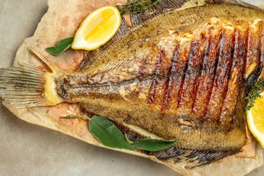 Baked Flounder Fish with herbs and lemon, Delicious balanced food concept, Restaurant menu, dieting, cookbook recipe top view,