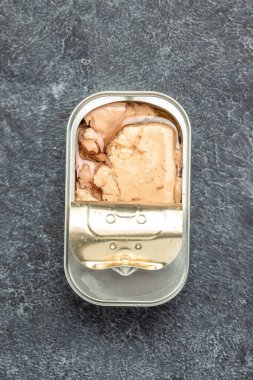 Open tin container with cod liver. Canned seafood, vertical image. top view. place for text.