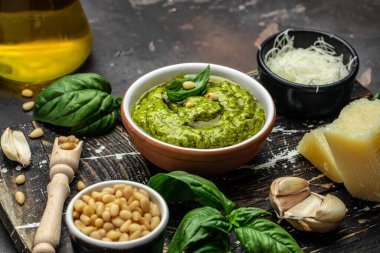 Green basil pesto with italian recipe ingredients, Basil, olive oil, parmesan, garlic, pine nuts. banner, menu, recipe place for text, top view,