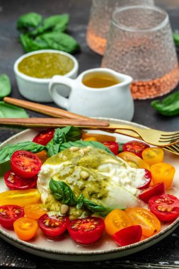 Salad burrata cheese tomatoes and green pesto. Delicious balanced food concept. superfood concept. Healthy, clean eating. Vegan or gluten free diet. top view.