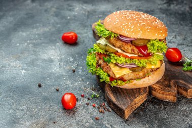 Sığır eti, domates, peynir, pastırma ve marullu ev yapımı leziz ızgara burger. Fast food ve abur cubur kavramı.