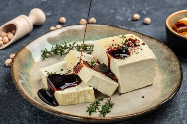 Teriyaki tofu. vegetarian tofu cubes on a dark background. banner, menu, recipe top view.