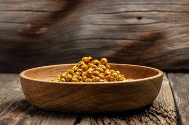 Ahşap masa arkasında kavrulmuş baharatlı nohut. afiş, menü, metin için tarif yeri, üst görünüm,