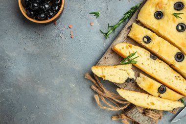 Ev yapımı Focaccia ekmeği, ahşap bir tahtanın üzerinde baharat ile pişiriliyor. afiş, menü, metin için tarif yeri, üst görünüm.