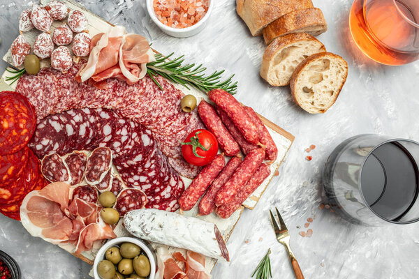 delicious salami, pieces of sliced prosciutto crudo, sausage and wine. Meat platter. Mixed delicatessen of meat snacks. place for text, top view.