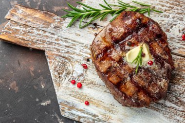 Grilled beef steak on a wooden board. banner, menu, recipe place for text, top view.